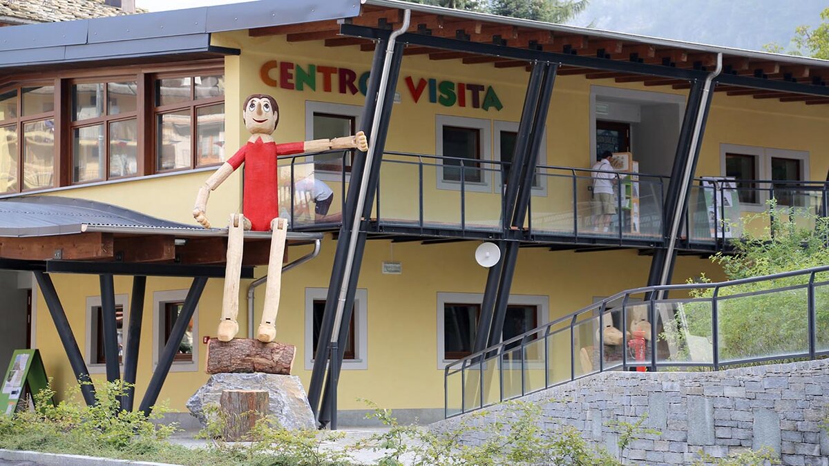 Il Centro di visita di Vernante visto dalla SS20; spicca il grande pinocchio di legno vestito di rosso.
